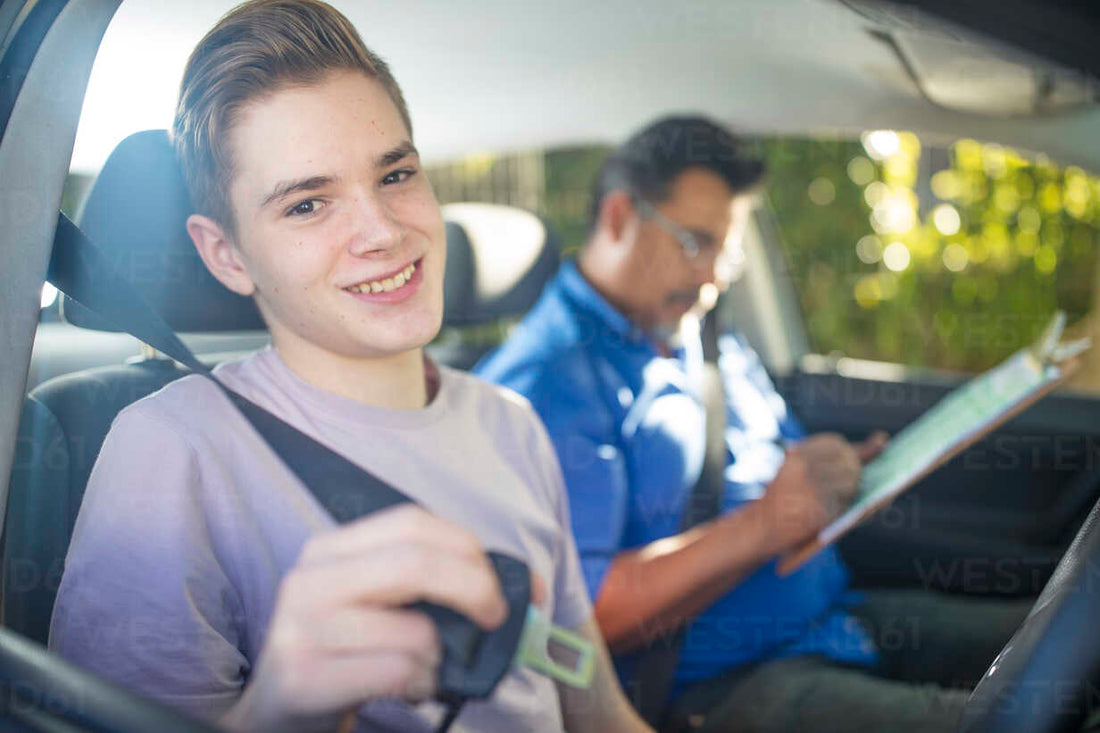 Young male learner driver celebrating with instructor after successfully passing his driving test, holding car keys with a smile.