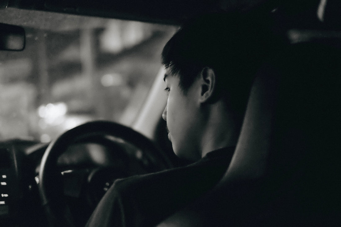 grayscale photography of man driving car