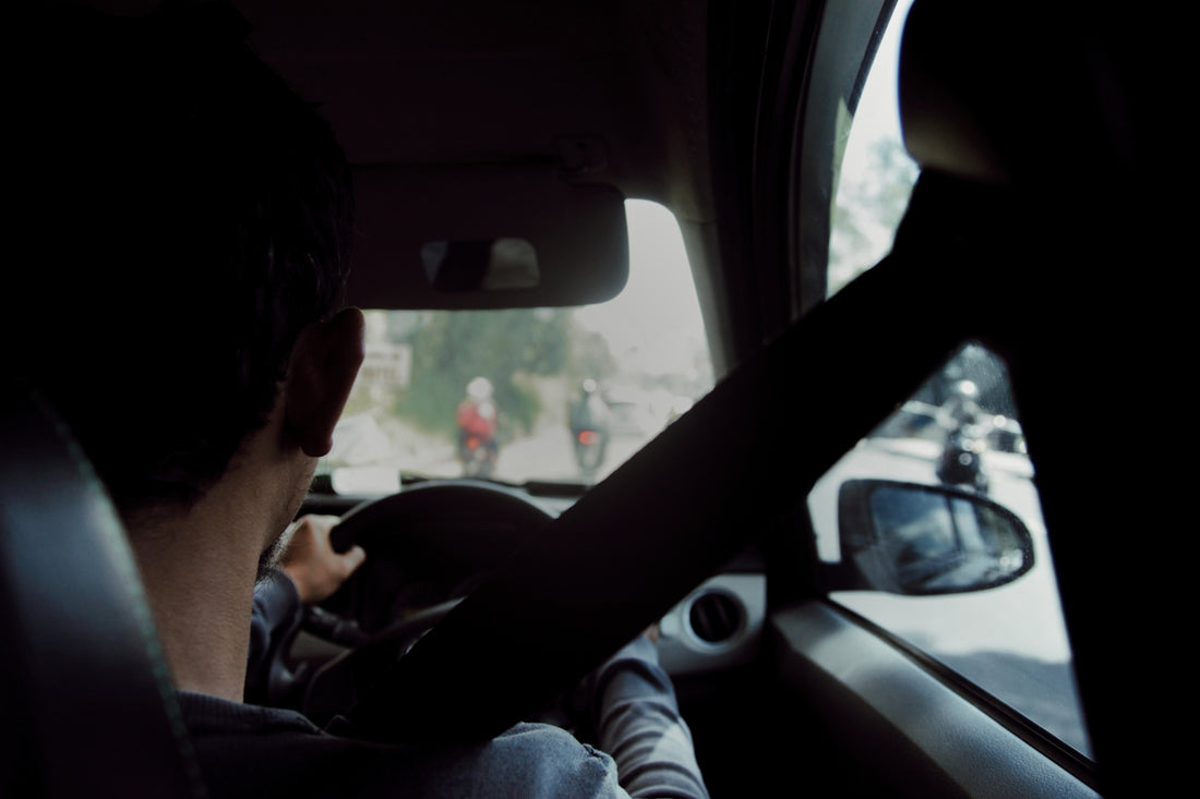 man in gray long sleeve shirt driving car
