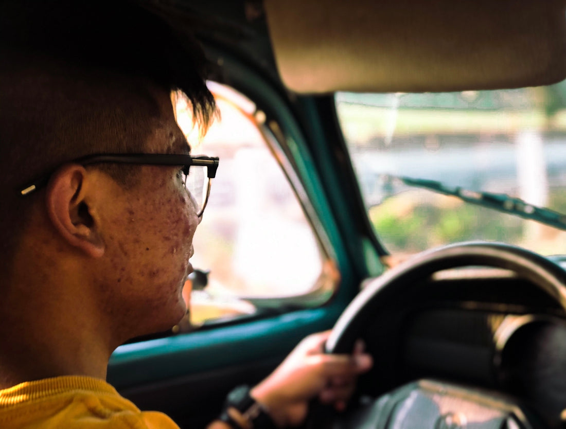 man in yellow shirt driving car