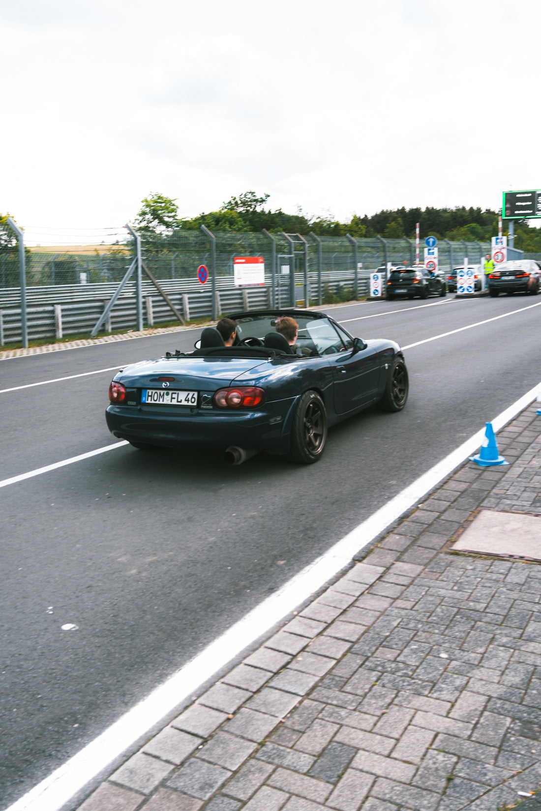 A car driving down a street next to a street sign